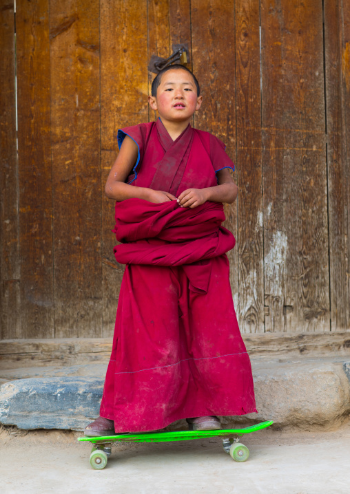 Young tibetan monk on a skateboard in Lhachub monastery, Gansu province, Lhachub, China
