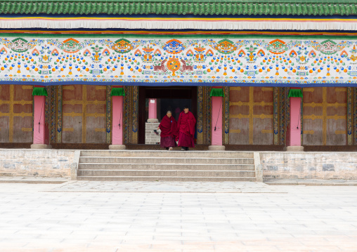 Tibetan monks coming out of a temple in Labrang monastery, Gansu province, Labrang, China