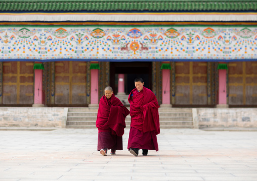 Tibetan monks coming out of a temple in Labrang monastery, Gansu province, Labrang, China