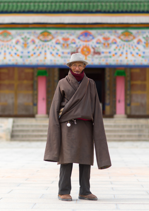 Portrait of a tibetan man wearing a coat with very long sleeves to protect from the cold, Gansu province, Labrang, China