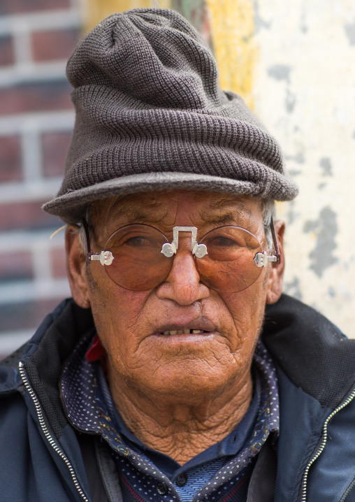 Tibetan man with sunglasses during a pilgrimage in Labrang monastery, Gansu province, Labrang, China