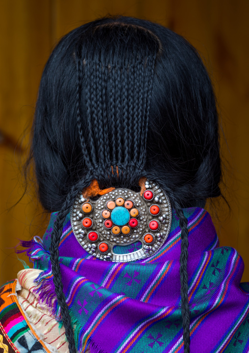 Nyingma tibetan nomad wearing a silver and coral plaque in her braided hair, Gansu province, Labrang, China
