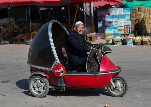 Cute small three-wheeled chinese retro car in the street, Gansu province, Linxia, China