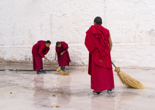 Buddhist monks in red robes are cleaning Rongwo monastery, Tongren County, Longwu, China