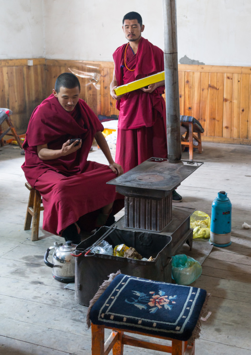 Tibetan monks in front of a stove, Gansu province, Labrang, China