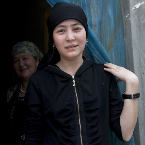 Young Uyghur Woman And Her Mother At The Entrance Of Their House, Keriya, Xinjiang Uyghur Autonomous Region, China