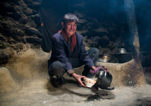 Wakhi teenage boy preparing salty milk tea inside his house, Big pamir, Wakhan, Afghanistan