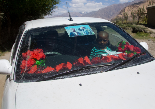 Afghan boy inside a car with ahmad shah massoud poster on the windshield, Badakhshan province, Khandood, Afghanistan
