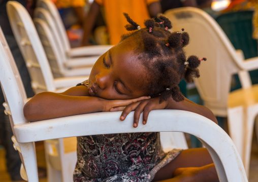 Benin, West Africa, Porto-Novo, little girl sleeping on a chair arm