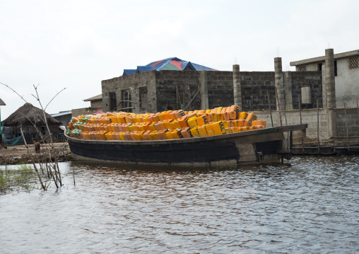 Benin, West Africa, Ganvié, boat carrying oil jerrycans on lake nokoue