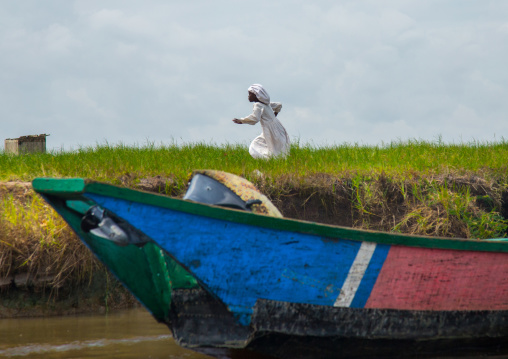 Benin, West Africa, Ganvié, celest church girl running on the bansk of lake nokoue