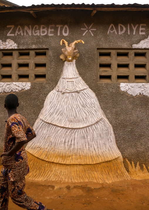Benin, West Africa, Porto-Novo, young man passing in front of zangbeto adiye temple