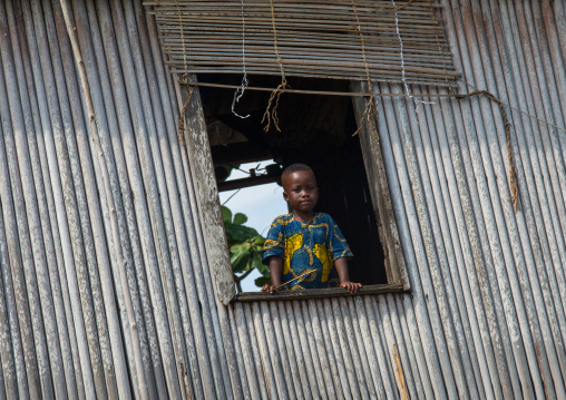 Benin, West Africa, Ganvié, child looking over a window in a leaning stilt house on lake nokoue