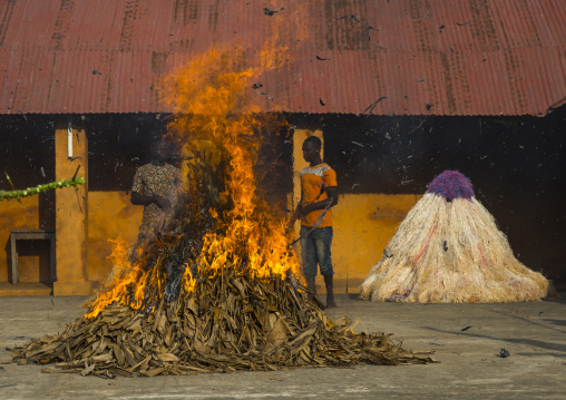 Benin, West Africa, Porto-Novo, men putting fire to a zangbeto guardian of the night in the royal palace