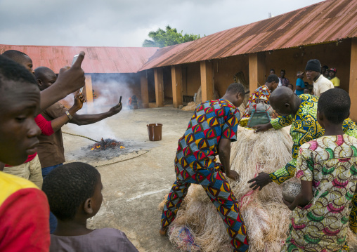 Benin, West Africa, Porto-Novo, men showing there is nobody inside the zangbeto guardian of the night in the royal palace