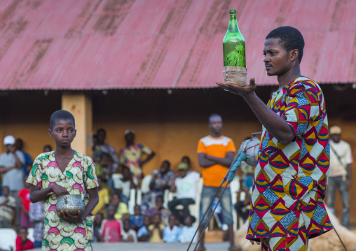 Benin, West Africa, Porto-Novo, man showing a bottle kept by a zangbeto guardian of the night in the royal palace
