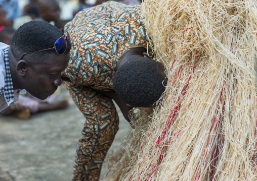 Benin, West Africa, Porto-Novo, men speaking to a zangbeto guardian of the night spirit in the royal palace