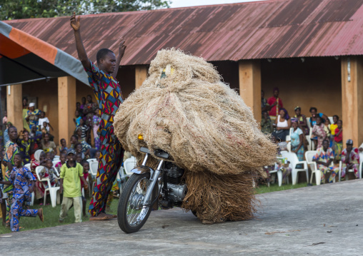 Benin, West Africa, Porto-Novo, zangbeto guardian of the night spirit riding motorcycle in the royal palace