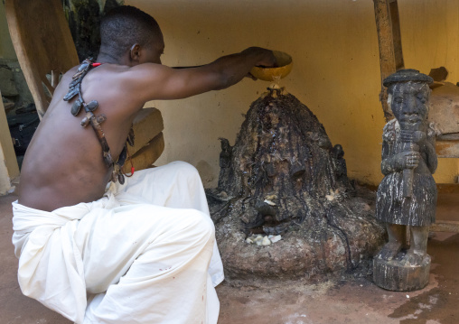 Benin, West Africa, Bonhicon, kagbanon bebe voodoo priest putting some oil on a fetish during a ceremony