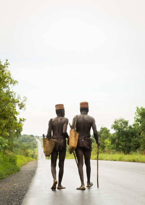 Benin, West Africa, Taneka-Koko, traditional healers walking on a concrete road