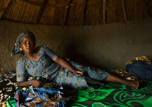 Benin, West Africa, Taneka-Koko, peul bride waiting for her groom lying on her bed inside her hut