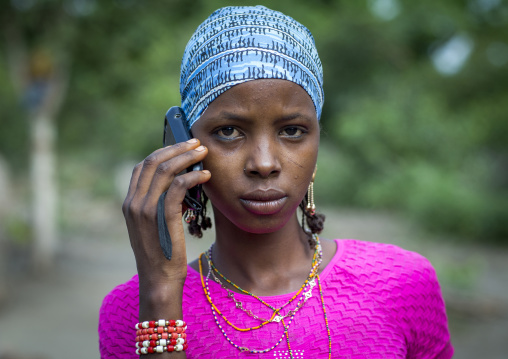 Benin, West Africa, Gossoue, a beautiful tattooed fulani peul tribe woman pausing with her mobile phone