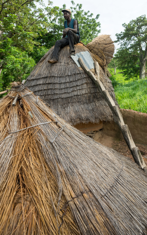 Togo, West Africa, Nadoba, man standing on the roof of a traditional tata somba house