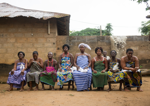 Benin, West Africa, Bopa, women sitting on bench in line during a voodoo ceremony