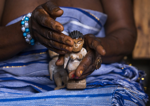 Benin, West Africa, Bopa, miss hounyoga dressing the carved wooden figures of her dead twins