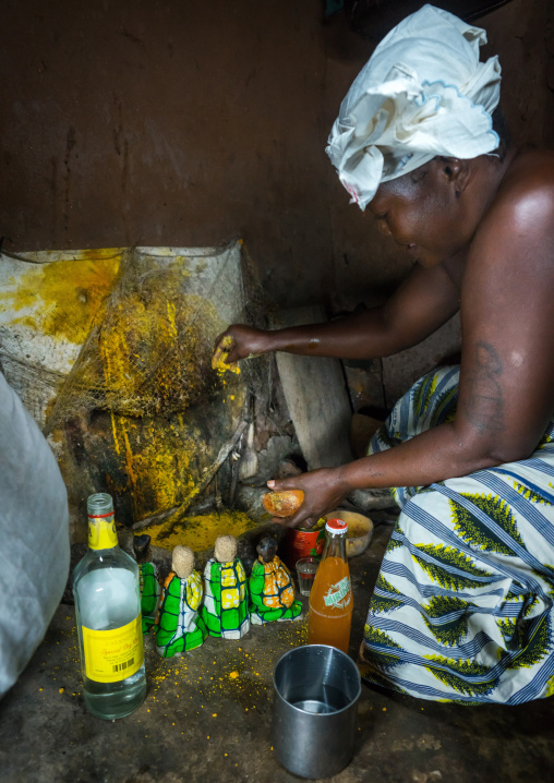 Benin, West Africa, Bopa, miss ablossi giving drink to the carved wooden figures made to house the soul of her five dead twins