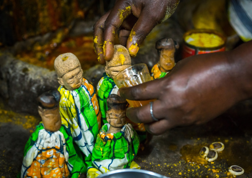 Benin, West Africa, Bopa, miss ablossi giving drink to the carved wooden figures made to house the soul of her five dead twins