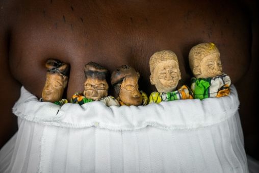 Benin, West Africa, Bopa, miss ablossi carrying the carved wooden figures made to house the soul of her five dead twins