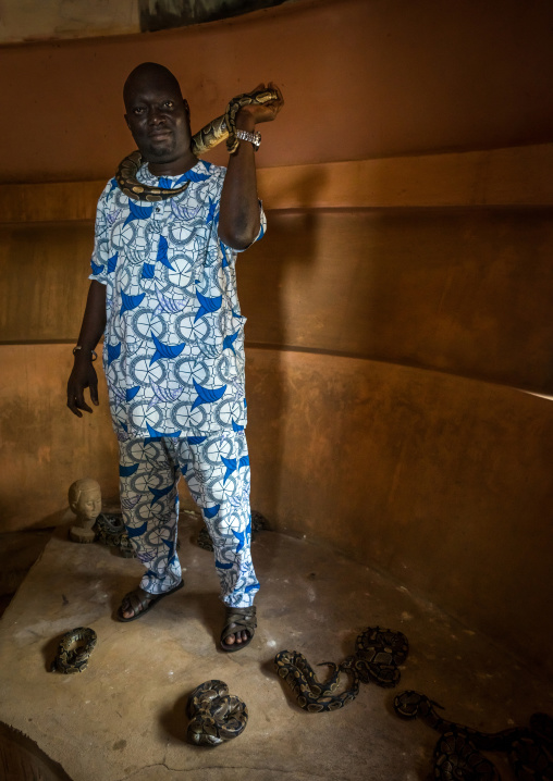 Benin, West Africa, Ouidah, man holding a snake in the python temple