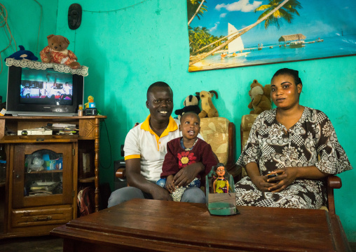 Benin, West Africa, Ouidah, eric, tatiana, and their son paterne in front of the carved wooden figure made to house the soul of their dead twin paterna