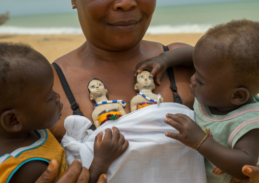 Benin, West Africa, Ouidah, mrs kpsouayo carrying the statues of her dead twins and her two boys twins