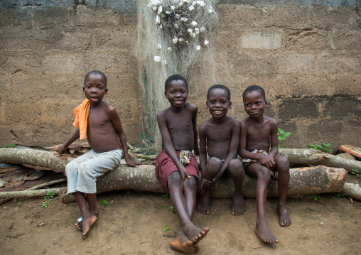 Benin, West Africa, Bopa, children sit on wood trunk
