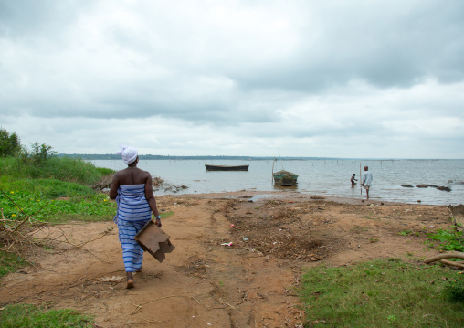 Benin, West Africa, Bopa, miss hounyoga going to bath the carved wooden figures made to house the soul of her dead twins in the lake