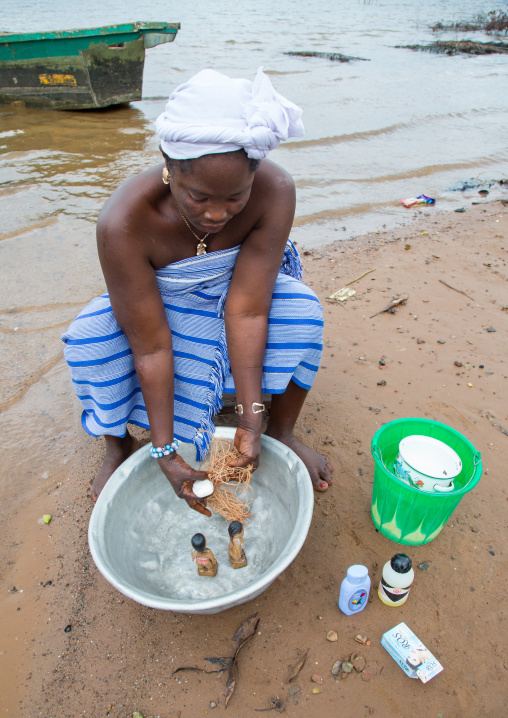 Benin, West Africa, Bopa, miss hounyoga washing the carved wooden figures made to house the soul of her dead twins