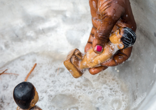 Benin, West Africa, Bopa, miss hounyoga washing the carved wooden figures made to house the soul of her dead twins