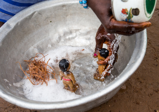 Benin, West Africa, Bopa, miss hounyoga washing the carved wooden figures made to house the soul of her dead twins