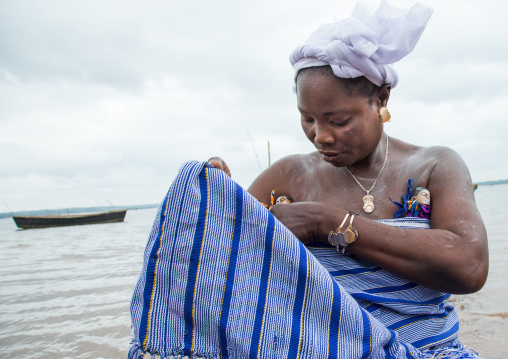 Benin, West Africa, Bopa, miss hounyoga carrying the carved wooden figures made to house the soul of her dead twins
