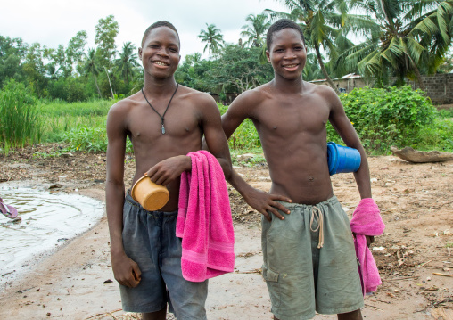 Benin, West Africa, Bopa, twin teenagers going to have a bath in the lake