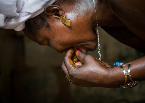 Benin, West Africa, Bopa, mrs hounyoga cuts a cola nut to make offerings to the twins spirits in the temple