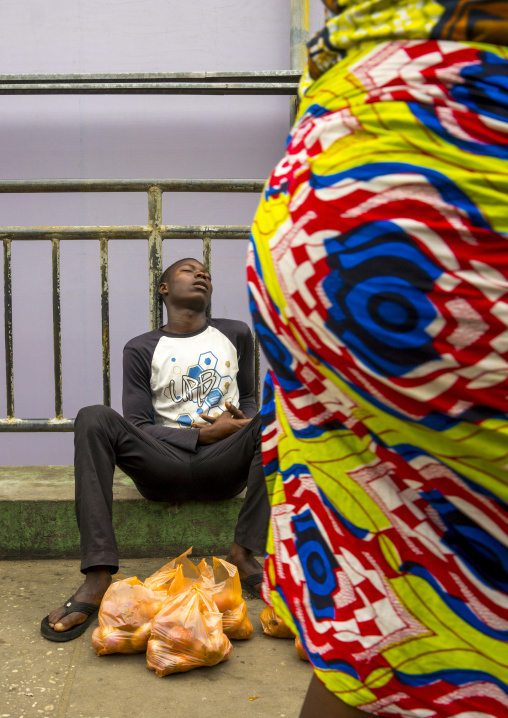 Benin, West Africa, Cotonou, man asleep in dantokpa market