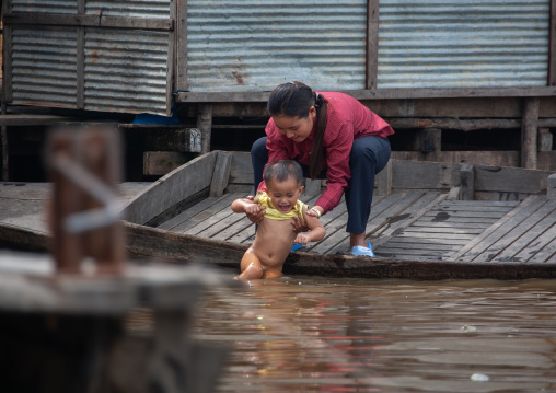 Cambodian mother giving a bath in Tonle Sap lake, Siem Reap Province, Chong Kneas, Cambodia