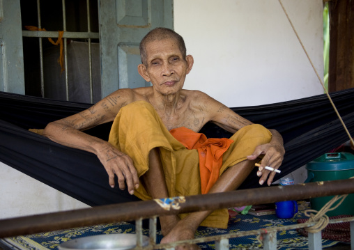 Tatooed monk on a hammock in a monastery, Battambang province, Battambang, Cambodia