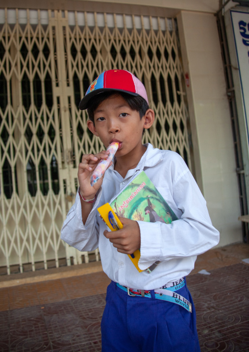 Portrait of boy eating ice cream while standing on street, Battambang province, Battambang, Cambodia
