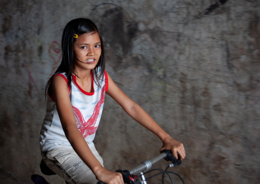 Portrait of a cambodian girl riding a bicycle, Phnom Penh province, Phnom Penh, Cambodia
