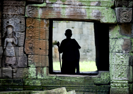 Monk silhouette standing in a temple vestige in Angkor wat, Siem Reap Province, Angkor, Cambodia