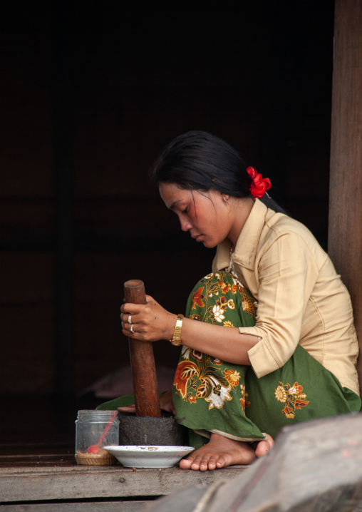 Cambodian woman using a mortar and pestle in the floating village on Tonle Sap lake, Siem Reap Province, Chong Kneas, Cambodia